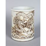 A CHINESE BLANC DE CHINE BRUSH POT, relief decorated with dragons. 5.5ins high.