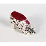 A PIERCED SILVER AND RUBY SET SHOE PIN CUSHION.