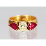 A 22CT YELLOW GOLD RUBY AND DIAMOND RING, the central diamond flanked by two pear shaped rubies.