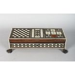 A GOOD ISLAMIC INLAID TRAVELLING CHESS BOX AND PIECES, on claw feet. 11ins wide.
