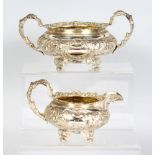 A GEORGE IV SUGAR BASIN AND MILK JUG with floral repousse decoration. London 1822. Maker: John