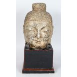 A CAST METAL HEAD OF A BUDDHA, 20TH CENTURY, on a lacquered wood plinth. Head: 9ins high.