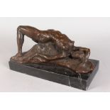 AN ABSTRACT BRONZE FEMALE NUDE, reclining on a rock, on a rectangular marble base. 1ft 1ins long.