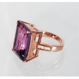 A 9CT GOLD LARGE AMETHYST RING with diamond shoulders.