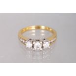 A 14K YELLOW GOLD AND DIAMOND THREE STONE RING.