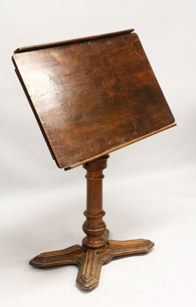 A 19TH CENTURY FRENCH MAHOGANY ADJUSTABLE READING TABLE, with tilting and rising top, on a turned