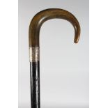 A WALKING CANE WITH RHINO CROOK HANDLE.