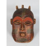 AN AFRICAN CARVED BIOMBO STYLE HELMET MASK with Horns, pierced eyes and mouth with three horns, dark