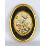 AN OVAL VICTORIAN EMBROIDERED BOUQUET OF FLOWERS, framed and glazed. 19ins x 13ins.