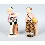 A PAIR OF GOLDSCHEIDER FIGURES, BOY WITH GOLF CLUBS AND GIRL PUTTING ON GLOVES. 7.5ins high.