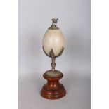 AN AUSTRALIAN MOUNTED EMU EGG, on a plated stand with small emu on the top. 9ins high including