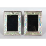 A PAIR OF SILVER AND ENAMEL PHOTOGRAPH FRAMES. 7ins high x 6ins wide.