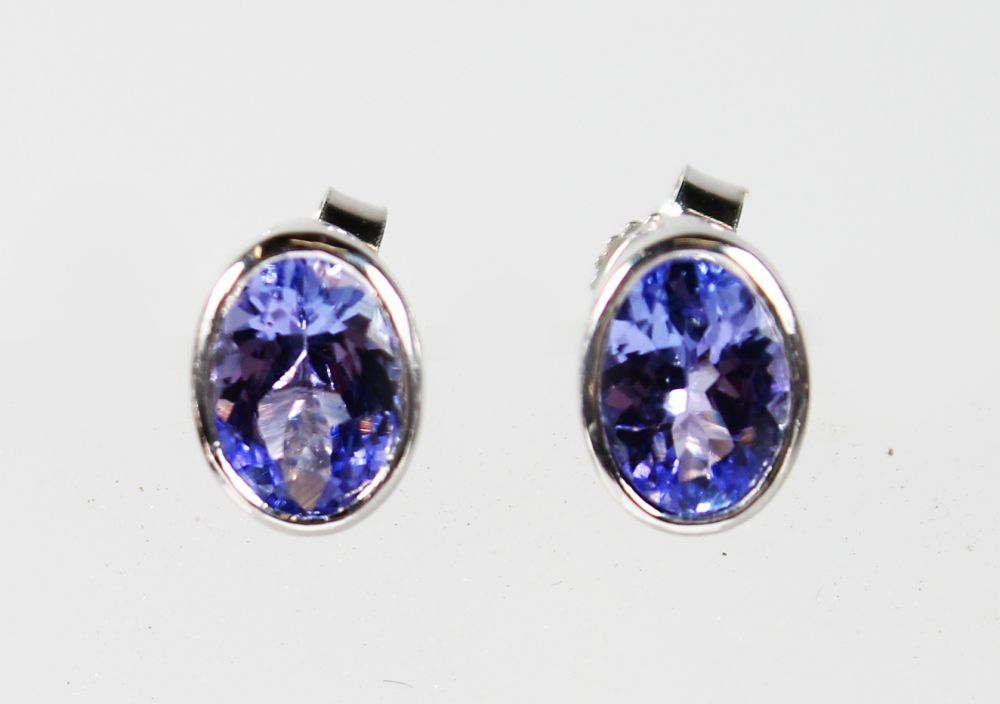 A PAIR OF 9CT WHITE GOLD AND TANZANITE EARRINGS.