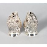 A GOOD PAIR OF SILVER BOAR'S HEAD SALT AND PEPPERS with ruby eyes.