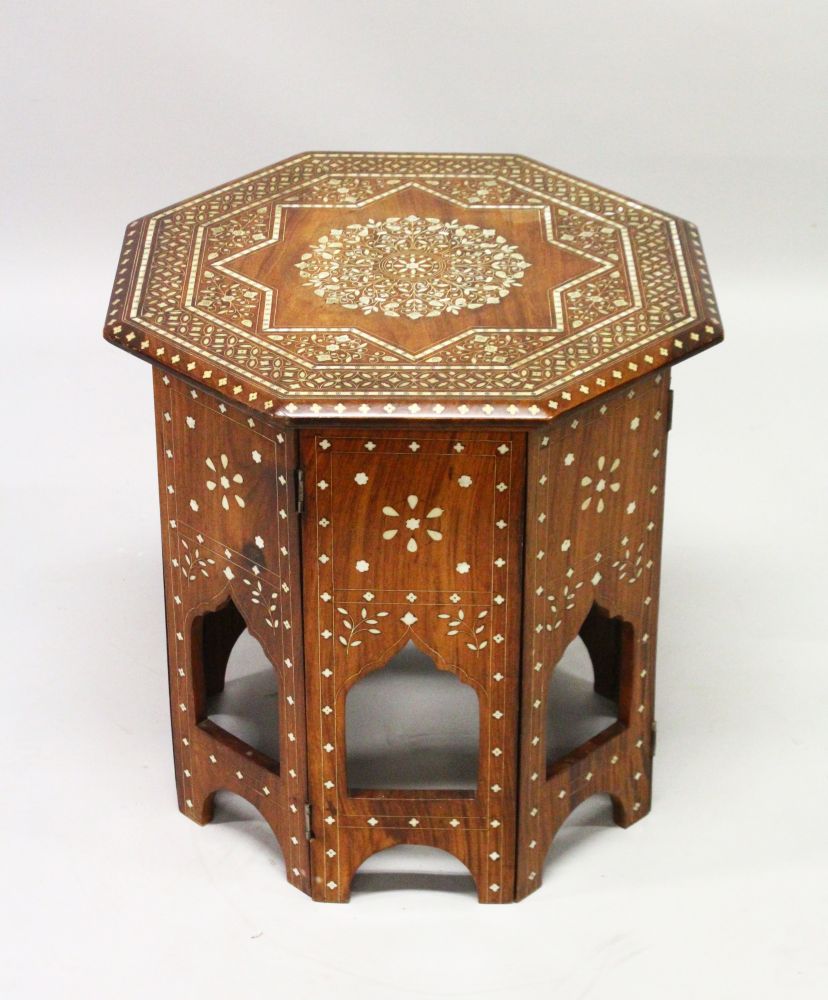 AN INDIAN OCTAGONAL SHAPED FOLDING TABLE, CIRCA 1900, with profusely inlaid floral decoration. 1ft
