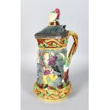 A MINTON MAJOLICA CARNIVAL JESTER JUG, the body with figures dancing around a castle wall, with