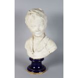 AFTER HOUDON. A WHITE PORCELAIN BUST OF A YOUNG BOY, Signed Houdon, on a blue base. 13ins high.