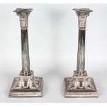 A GOOD PAIR OF LARGE VICTORIAN CORINTHIAN COLUMN CANDLESTICKS on squared loaded bases. 13ins high.