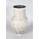 AN UNUSUAL SMALL VASE by RUPERT SPIRA, of bulbous form, pale grey matt glaze with fine lilac