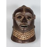 AN AFRICAN CARVED WOOD HELMET MASK, POSSIBLY IGALA, pierced eyes and mouth, with carved pattern to