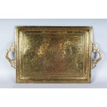 A LARGE CIRCA 1900 INDIAN BRASS CHASED AND DECORATED TWO HANDLED TRAY. 20ins long.