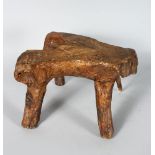 A RARE EARLY ROOTWOOD STOOL, with shaped top on four branch feet. 13ins long x 8ins high.