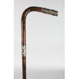 A WALKING CANE, with silver handle and band.