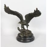 A BRONZE EAGLE with outstretched wings. 14ins high, on a circular marble base.