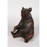 A BLACK FOREST CARVED WOOD SEATED BEAR TOBACCO JAR with hinged head and glass eyes. 8ins high.