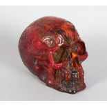 AN UNUSUAL AMBER STYLE MODEL OF A HUMAN SKULL. 6ins long.