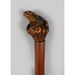 A FOLK ART WALKING STICK with carved frog handle.