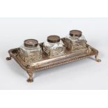 A GEORGE III RECTANGULAR INKWELL with gadrooned edge. three pierced bottle holders, three bottles