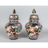 A PAIR OF JAPANESE IMARI STYLE VASES AND COVERS, decorated with cranes, flowers and trees. 1ft
