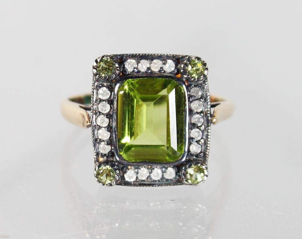 A 15CT GOLD AND SILVER PERIDOT AND DIAMOND RING.