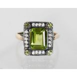 A 15CT GOLD AND SILVER PERIDOT AND DIAMOND RING.