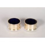 A PAIR OF CIRCULAR SILVER SALTS with sapphire blue liners, LONDON.
