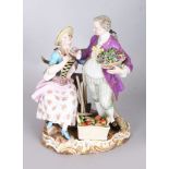 A GOOD 19TH CENTURY MEISSEN GROUP OF A GALLANT carrying a basket of flowers, a young lady seated