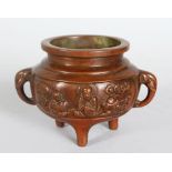A SMALL CHINESE BRONZE CENSER, on three feet. 4ins diameter.