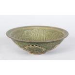 A CHINESE CELLADON BOWL, with incised and pierced decoration. 7ins diameter.