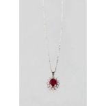 A 9CT GOLD OVAL RUBY AND DIAMOND PENDANT AND CHAIN.