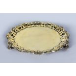 A SILVER GILT PIE CRUST SALVER with shell border on three knurled feet. 10.5ins diameter. Birmingham