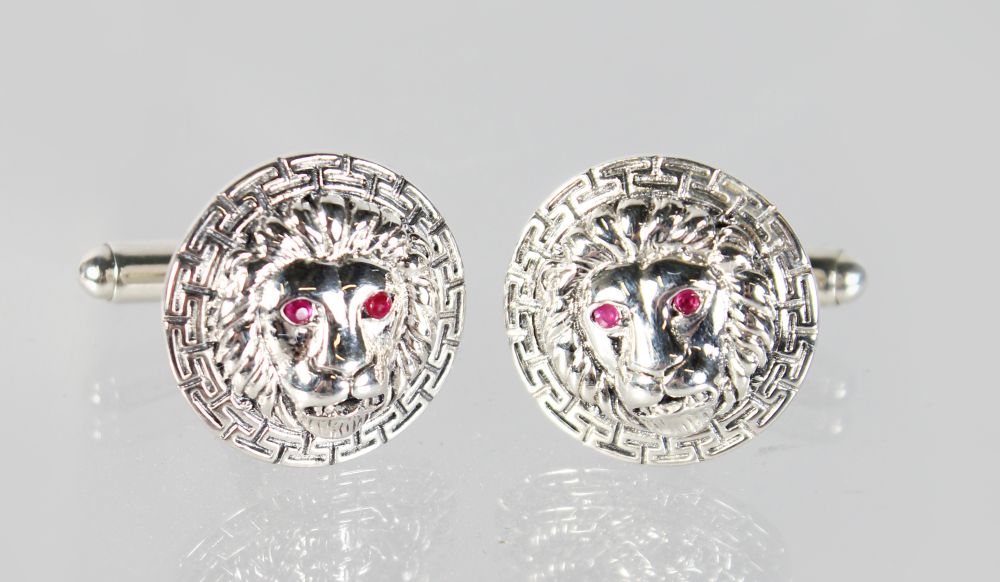 A GOOD PAIR OF SILVER "LION'S HEAD" CUFFLINKS with ruby eyes.