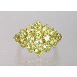 A 14K YELLOW GOLD AND PERIDOT CLUSTER RING.