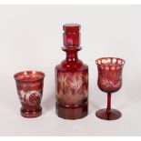A BOHEMIAN RUBY DECANTER AND STOPPER engraved with deer in a landscape, 10ins high, a beaker and a
