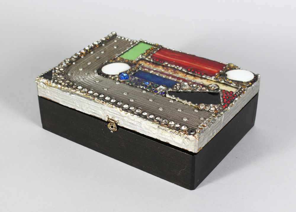 A JEWELLERY BOX, set with semi precious stones. 9ins long.