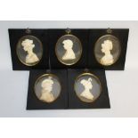 A SET OF FIVE CREAM COLOURED WAX PORTRAITS by LESLIE RAY, in ebony frames with glass ovals.