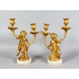 A VERY GOOD PAIR OF LOUIS XVI GILDED BRONZE CUPID TWO LIGHT CANDLESTICKS, formed as seated cupids