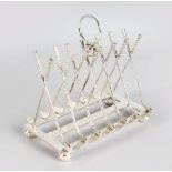 A PLATED TOAST RACK with seven pairs of crossed golf clubs and balls.