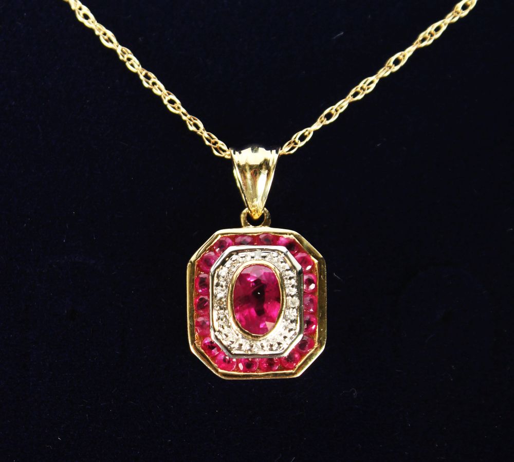 A 9CT GOLD, RUBY AND DIAMOND ART DECO DESIGN PENDANT AND CHAIN.