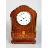 AN EDWARDIAN MAHOGANY INLAID MANTLE CLOCK, chiming, with white enamel dial. 12ins high.